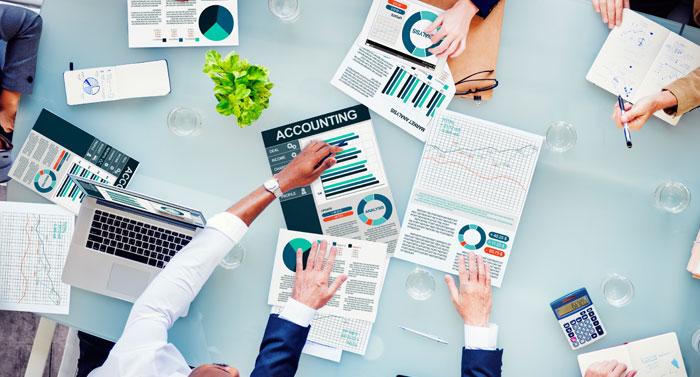 Overhead view of financial documents and business team working